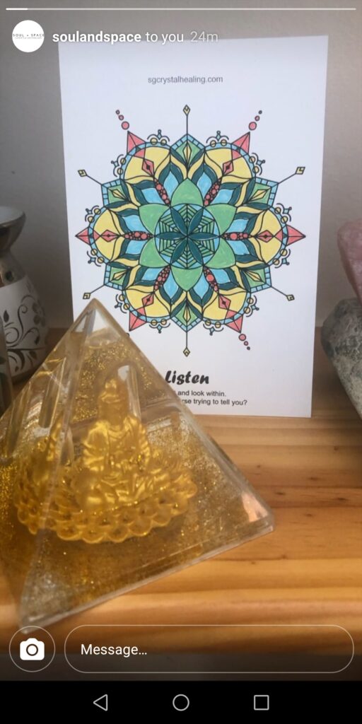 "How to use Oracle Mandalas: Placing them in your Space" depicts a beautiful mandala titled Listen on a desk with an orgone Pyramid. The mandala has been coloured in with green, blue , red and yellow colours.